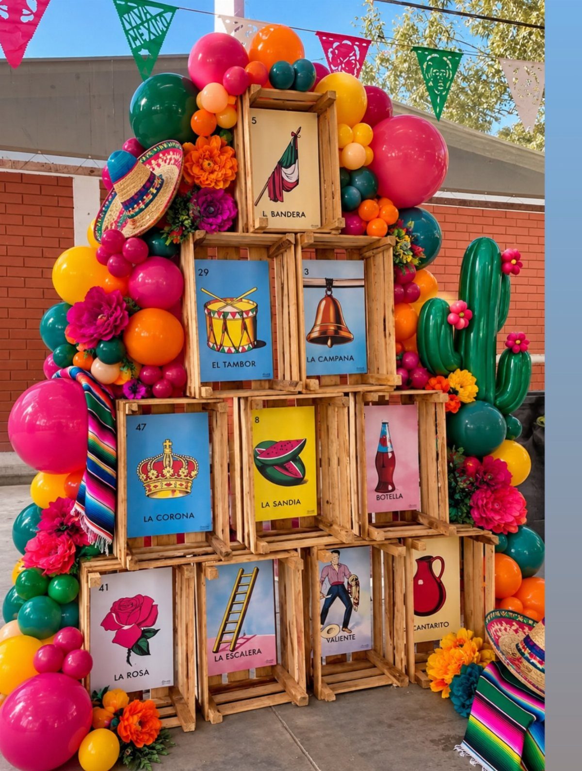 Festive 5 de mayo display with colorful balloons, wooden crates, and Mexican themed decor.