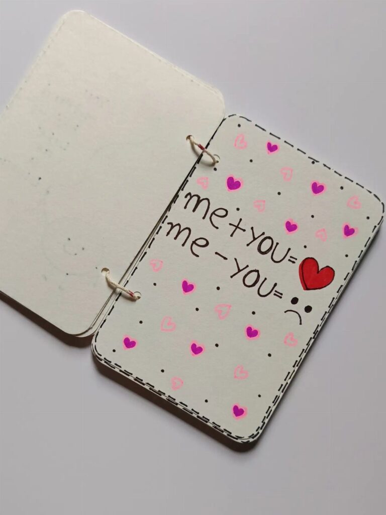 Handmade white notebook with heart drawings and romantic math equations on the cover.