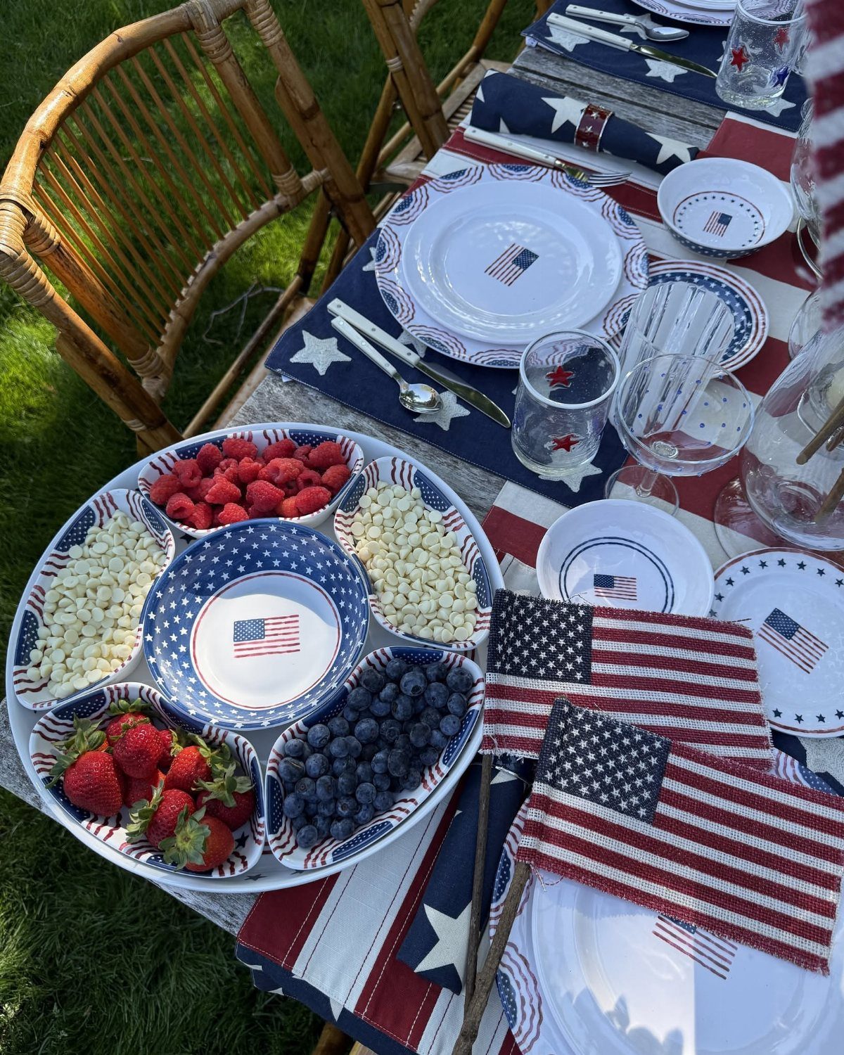 Patriotic table setting with red white and blue decor and a berry platter.