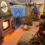 Cozy living room with a lit fireplace and decorated Christmas tree for holiday decor.