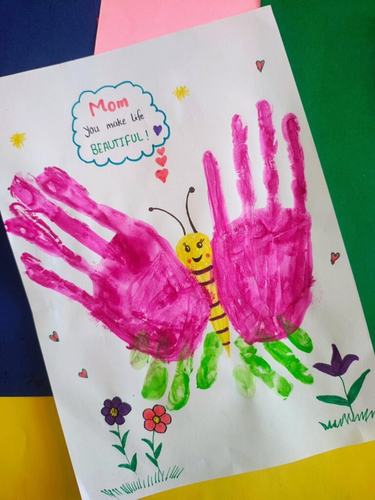 Handmade Mother's Day card with pink paint handprints and a painted bee